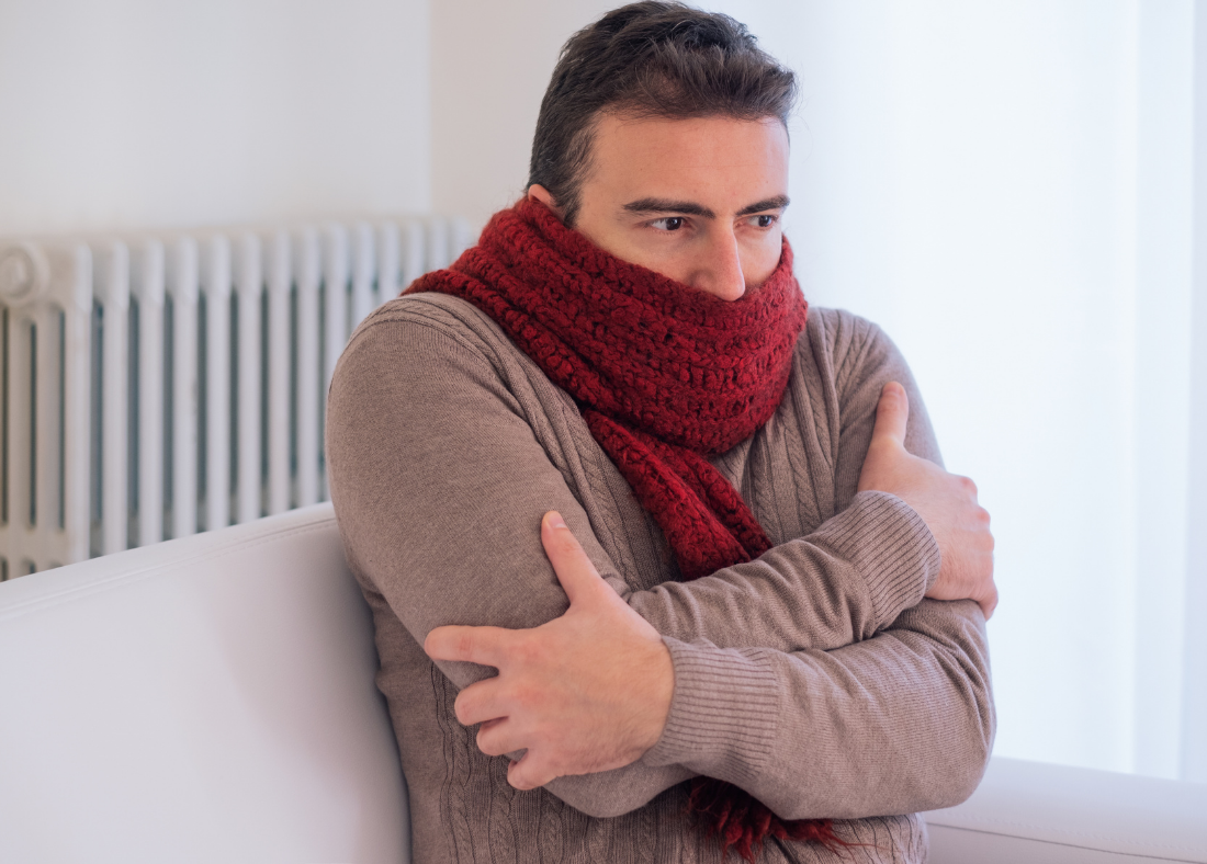 Man shivering in a scarf and jumper